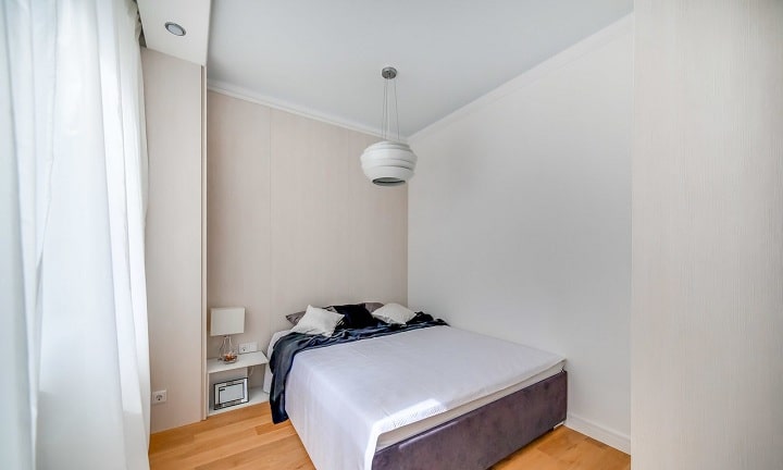 Зона спальни реализована в минималистическом стиле, светлой палитре. Обои под покраску на стенах, минимум освещения.