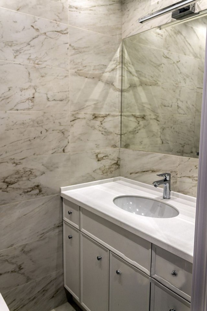 Фото зеркала с подсветкой и подвесной раковиной. Так как стиль в интерьере одинаковый, то и оформление в ванной комнате дублируется.